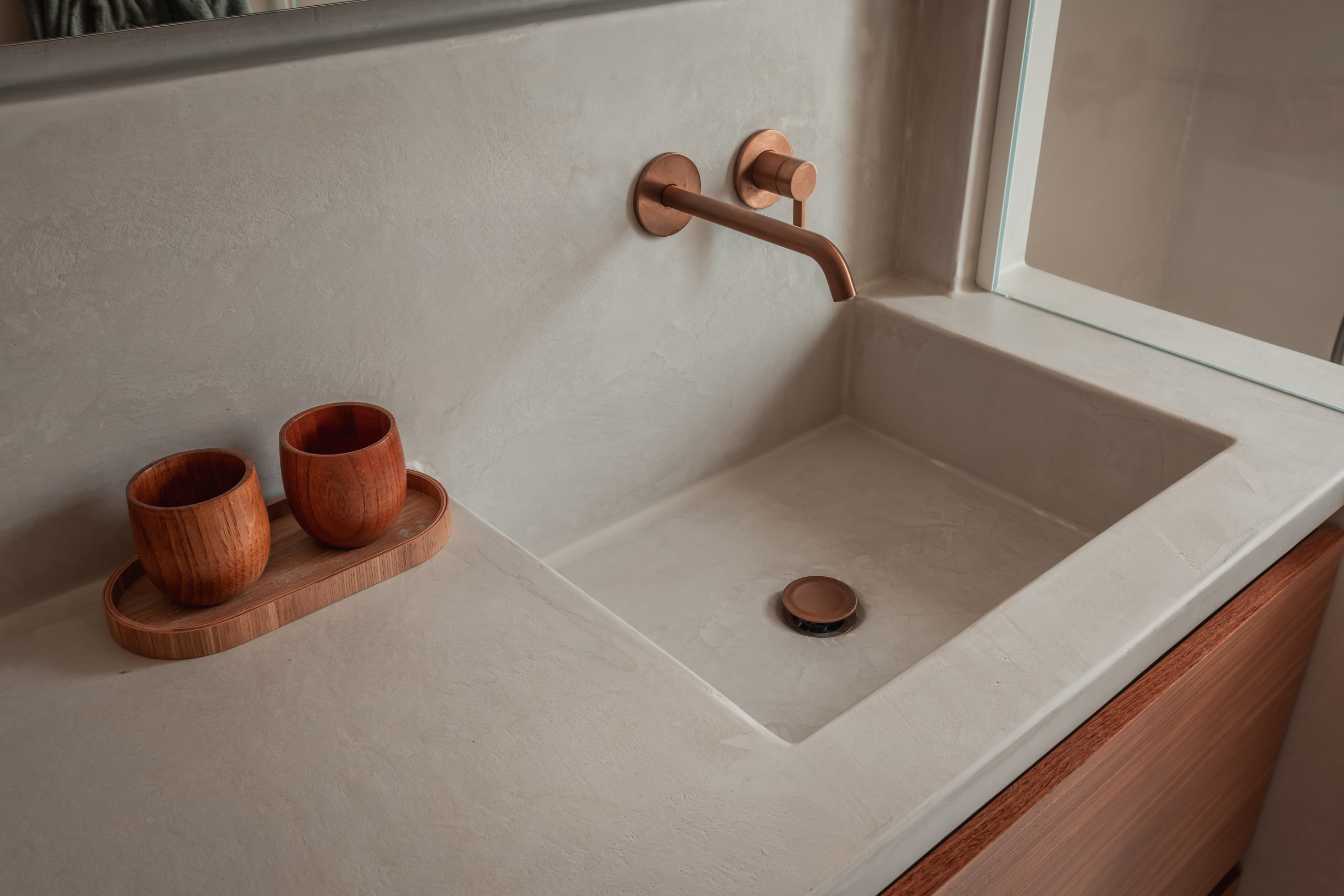 Wastafelzone met bronzen kraanwerk in Polynature badkamer te Menen