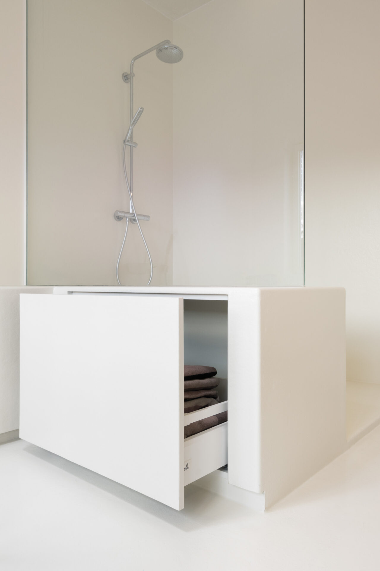 Maatwerkglas en opbergkast als zitbank in Voegloze Badkamer herenhuis Kortrijk
