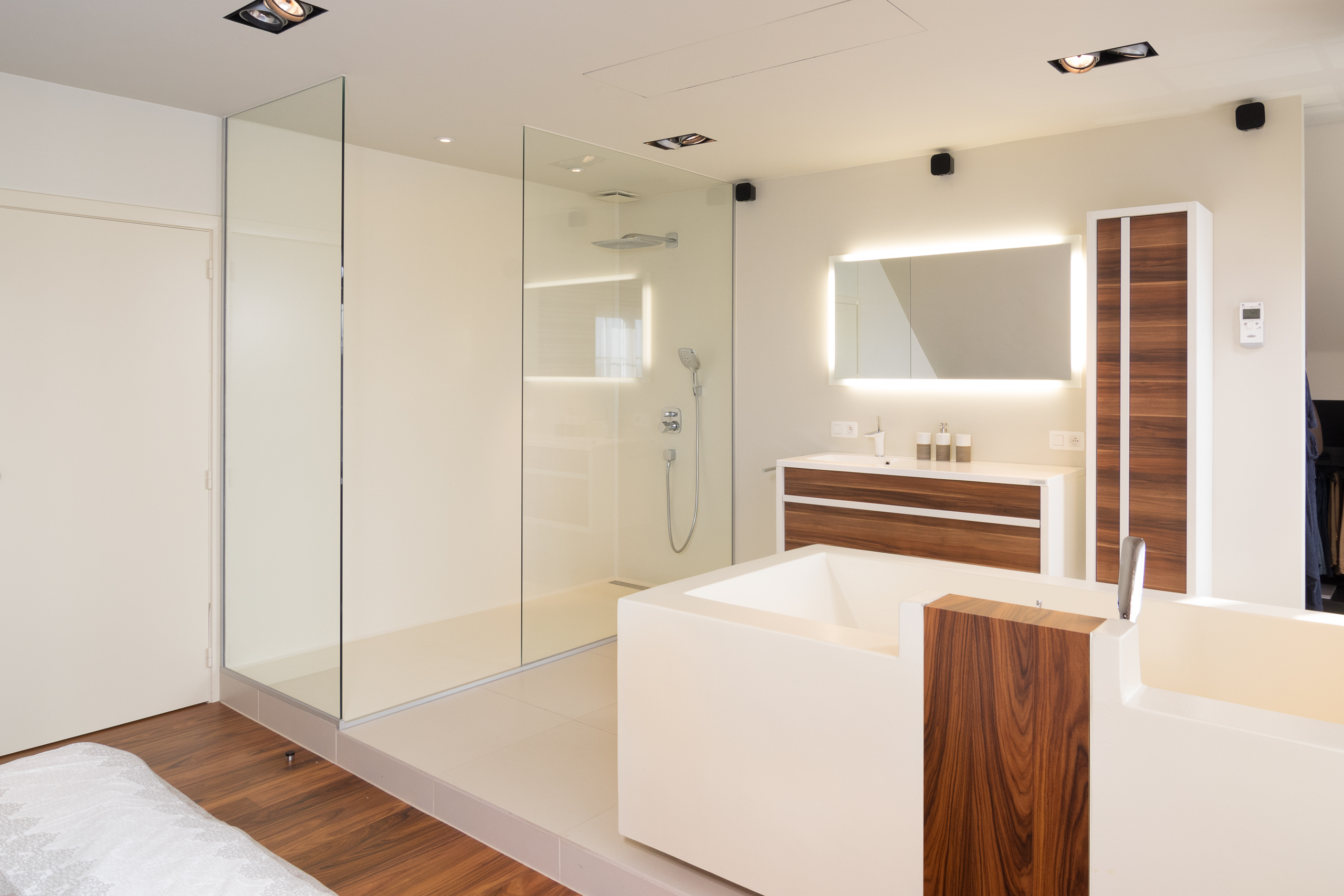 Totaalbeeld van masterbedroom met geïntegreerde Voegloze Badkamer te Ledegem