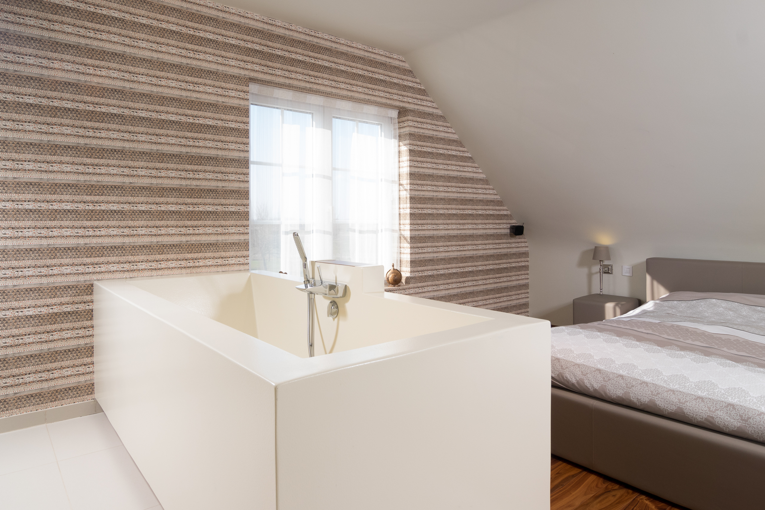 Op maat gemaakt bad bij de slaapkamer in voegloze masterbedroom te Ledegem