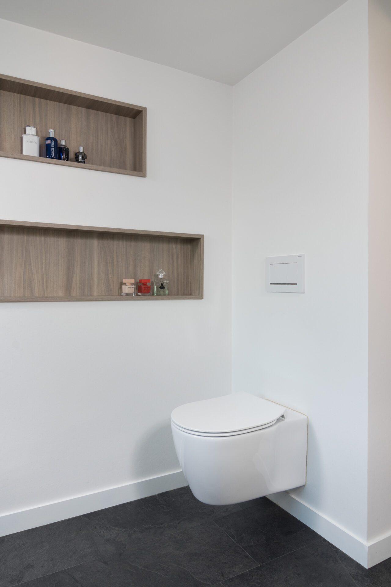 Valse wanden achter het toilet voor extra diepte in Voegloze Badkamer Zandvoorde