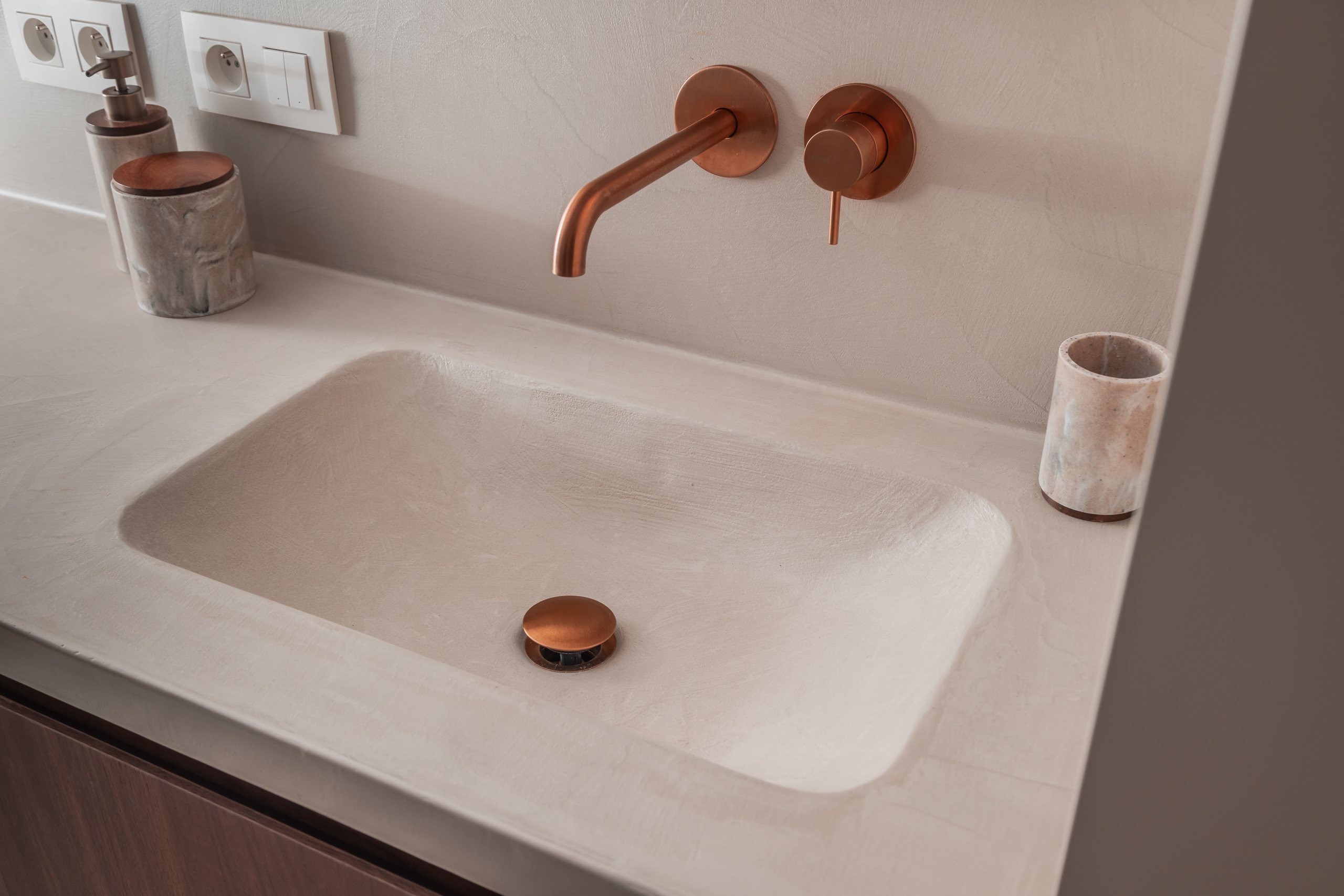 Wastafelzone met koperkraanwerk in Polynature badkamer te Evergem