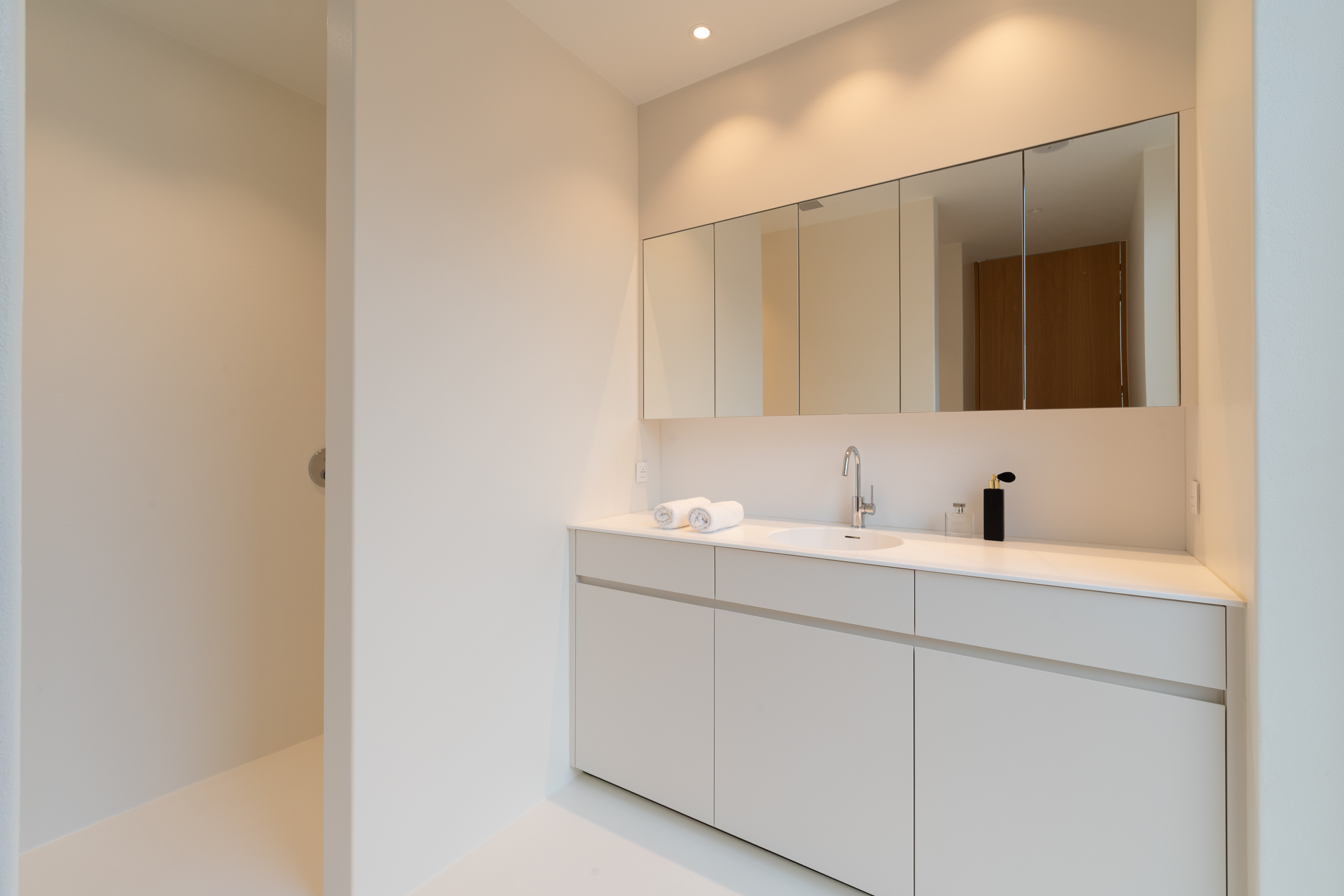 Tweede ensuite badkamer voegloos afgewerkt in Polycoat RAL 9010 te Avelgem