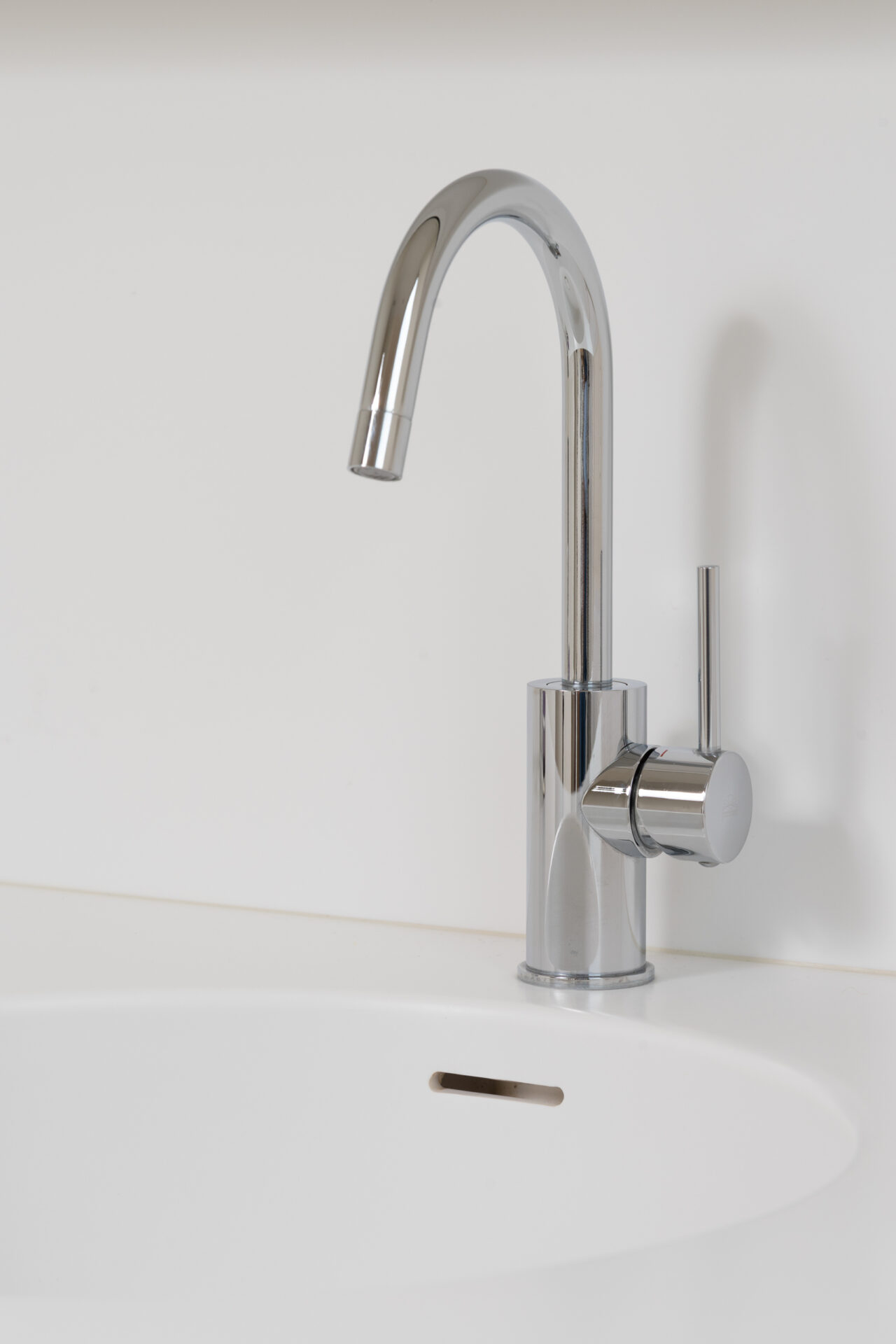 Wastafelzone met maatwerkmeubel in voegloze ensuite badkamer te Avelgem