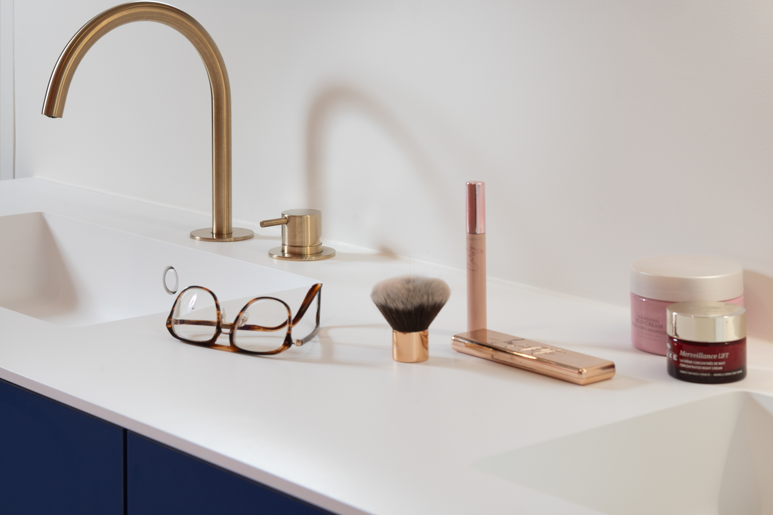Meubel met solid surface werkblad en donkerblauwe onderkast in badkamer Kortrijk