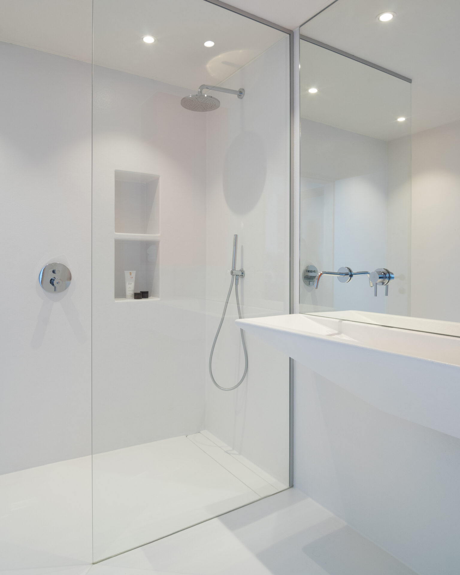Kleine badkamer zonder tegels met doorlopende wand- en vloerafwerking in witte kleur