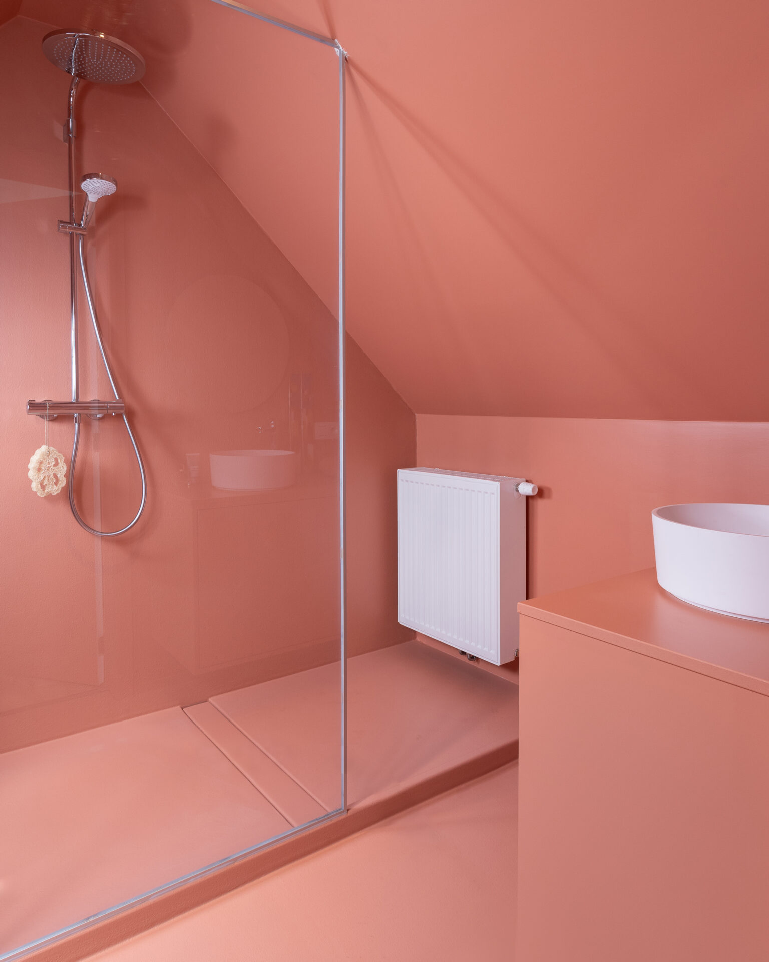 Rode terracotta badkamer zonder tegels met doorlopende wand- en vloerafwerking